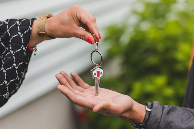 Two people exchanging a set of house keys